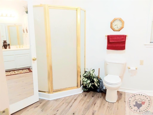 bathroom with vanity, toilet, walk in shower, and hardwood / wood-style floors