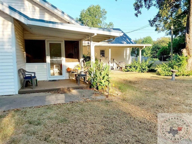 back of property with a patio area and a yard