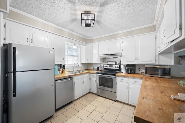 kitchen featuring under cabinet range hood, a sink, wood counters, white cabinets, and appliances with stainless steel finishes