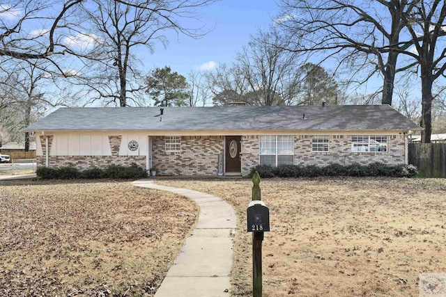 ranch-style house featuring brick siding and fence