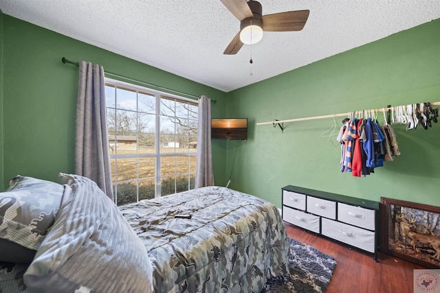 bedroom featuring a textured ceiling, ceiling fan, and wood finished floors