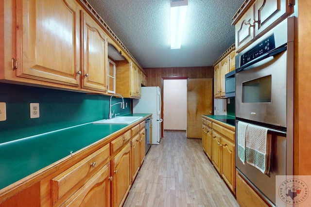 kitchen featuring sink, light hardwood / wood-style flooring, appliances with stainless steel finishes, and a textured ceiling