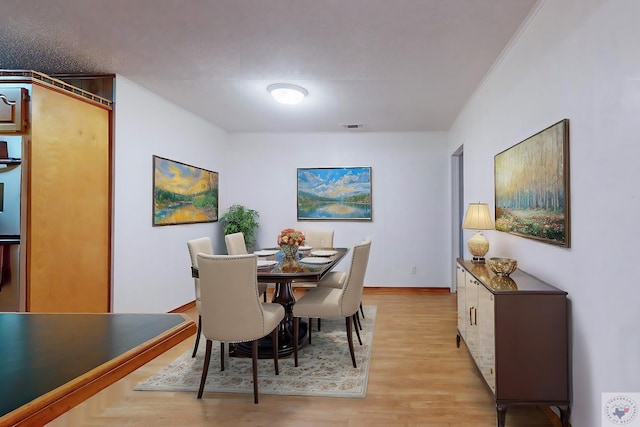 dining area featuring light hardwood / wood-style floors and a textured ceiling