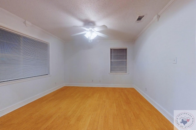 empty room featuring ceiling fan, light hardwood / wood-style flooring, ornamental molding, and a textured ceiling