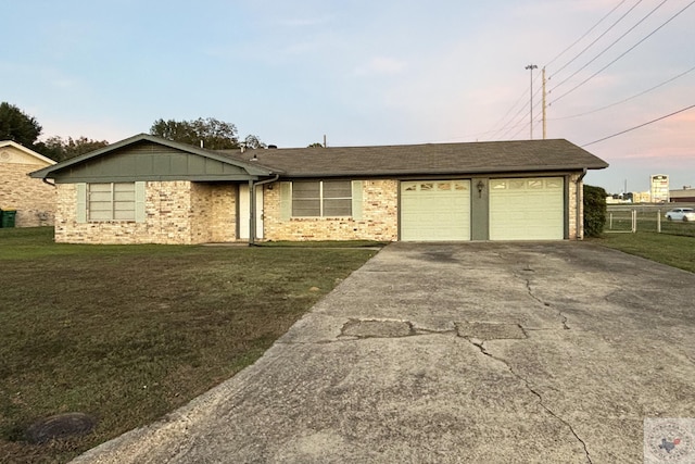 ranch-style home with a garage and a front lawn