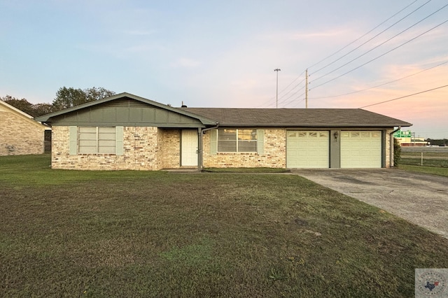 ranch-style house featuring a garage and a lawn