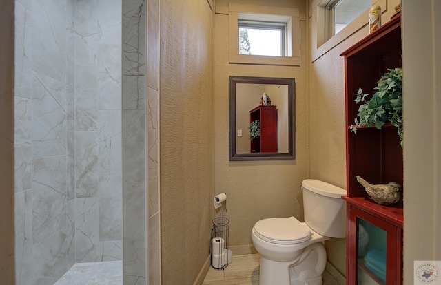 full bath with toilet, a shower with curtain, baseboards, and a textured wall