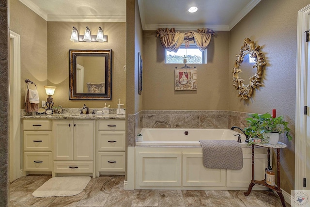 bathroom with ornamental molding, a garden tub, a textured wall, and vanity