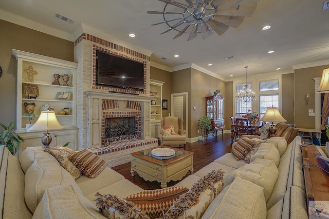 living room featuring dark wood-style flooring, a brick fireplace, visible vents, and crown molding