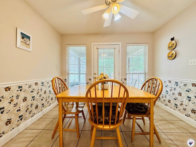 dining space with wainscoting, a wealth of natural light, and wallpapered walls