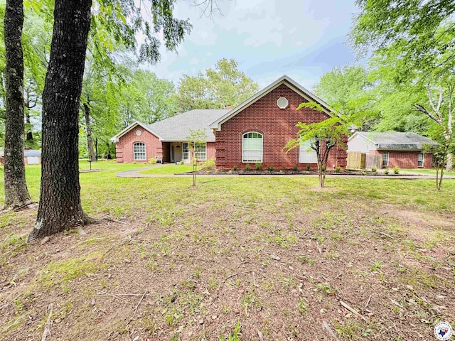 ranch-style house featuring a front lawn and brick siding