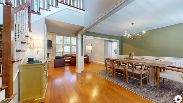 7109 Forest Oak Dr, Texarkana, AR 71854 - dining area featuring a chandelier, light wood-type flooring, stairway, and wainscoting