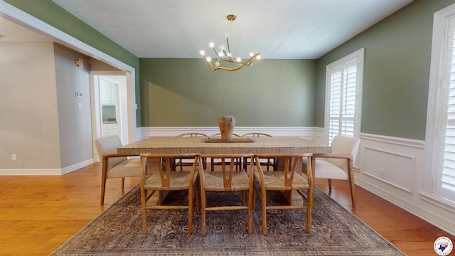 7109 Forest Oak Dr, Texarkana, AR 71854 - dining room featuring a chandelier, light wood-style flooring, and a wainscoted wall