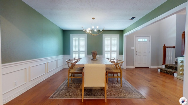 7109 Forest Oak Dr, Texarkana, AR 71854 - dining space with a chandelier, wood finished floors, wainscoting, stairs, and a decorative wall