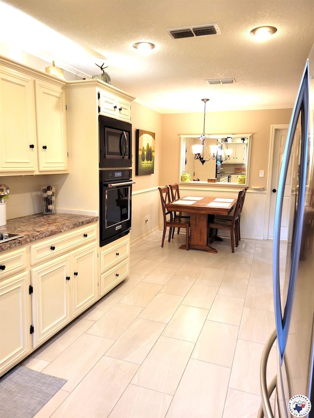 30 Hickory Oak Ln, Texarkana, TX 75501 - kitchen with visible vents, a textured ceiling, cream cabinetry, and black appliances
