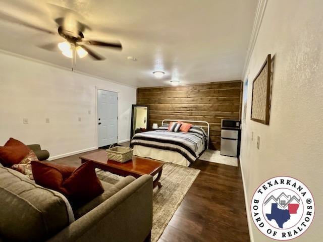 30 Hickory Oak Ln, Texarkana, TX 75501 - bedroom featuring dark wood finished floors, wood walls, an accent wall, baseboards, and ceiling fan