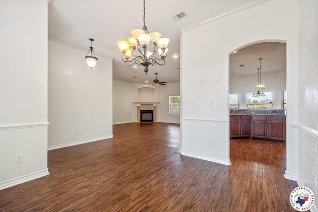 3604 Melody Ln, Texarkana, TX 75503 - unfurnished living room with plenty of natural light, dark wood-style floors, arched walkways, ornamental molding, and a fireplace
