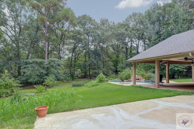 view of yard featuring ceiling fan and a patio area