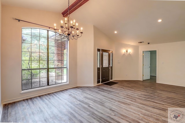 unfurnished room featuring a notable chandelier and vaulted ceiling with beams