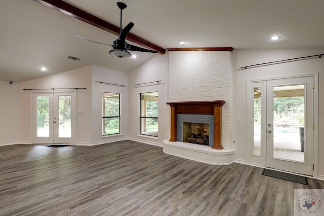 unfurnished living room featuring hardwood / wood-style floors, lofted ceiling with beams, french doors, and a fireplace