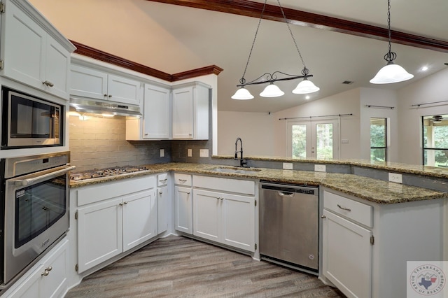 kitchen featuring white cabinetry, backsplash, appliances with stainless steel finishes, and hanging light fixtures