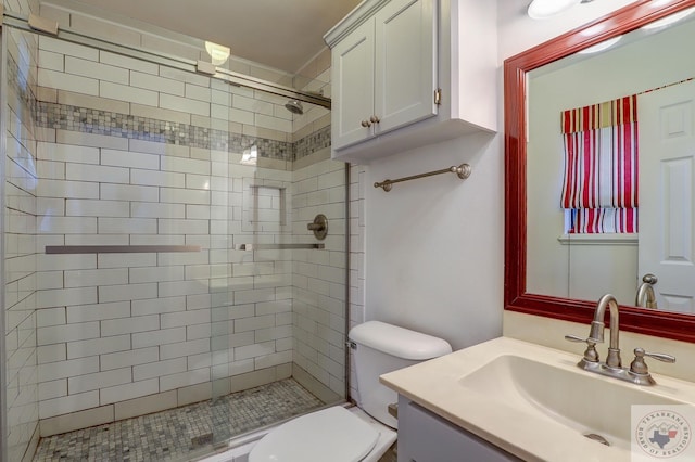 bathroom featuring toilet, vanity, and a tile shower