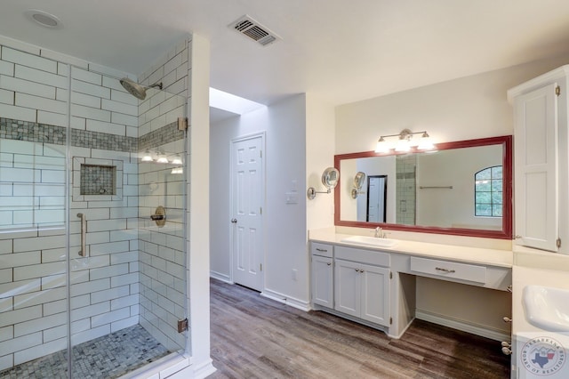 bathroom featuring hardwood / wood-style flooring, an enclosed shower, and vanity