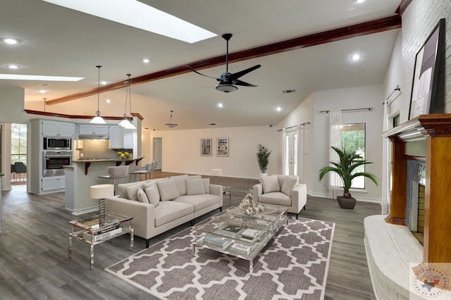 living room with beam ceiling, plenty of natural light, dark hardwood / wood-style flooring, and a skylight