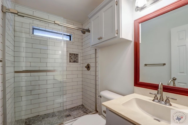 bathroom with an enclosed shower, vanity, and toilet