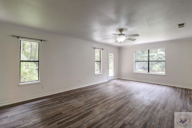 empty room with a wealth of natural light, dark hardwood / wood-style floors, and ornamental molding