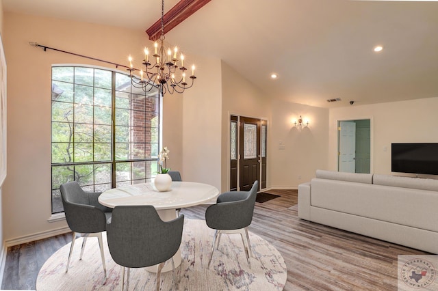 dining room featuring hardwood / wood-style flooring, lofted ceiling with beams, and a notable chandelier