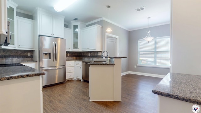 6908 Woodmere Ct, Texarkana, TX 75503 - kitchen with stainless steel appliances, a peninsula, dark wood finished floors, white cabinetry, and ornamental molding