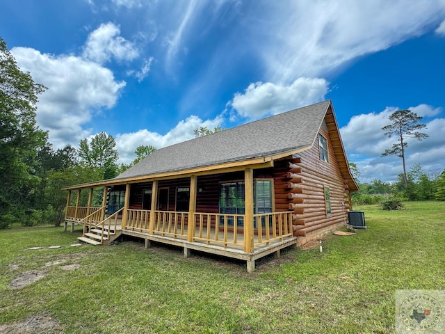 rear view of property with central AC unit, a wooden deck, and a yard