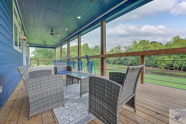 wooden deck featuring outdoor lounge area and ceiling fan