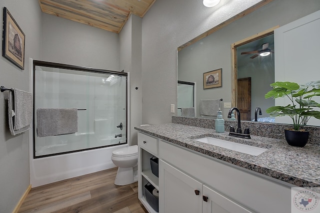 full bathroom featuring toilet, wooden ceiling, hardwood / wood-style flooring, shower / bath combination with glass door, and vanity