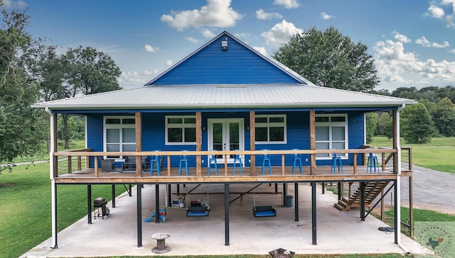 back of house featuring a wooden deck, a yard, and a patio