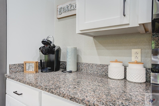 interior details featuring light stone counters and white cabinets