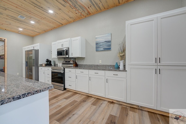 kitchen featuring white cabinets, appliances with stainless steel finishes, dark stone countertops, light wood-type flooring, and wooden ceiling