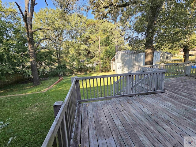 wooden terrace with a storage shed and a yard