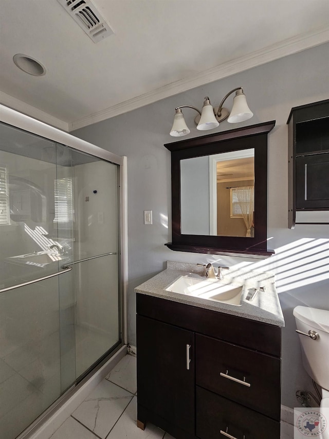 bathroom with ornamental molding, toilet, a shower with shower door, and vanity