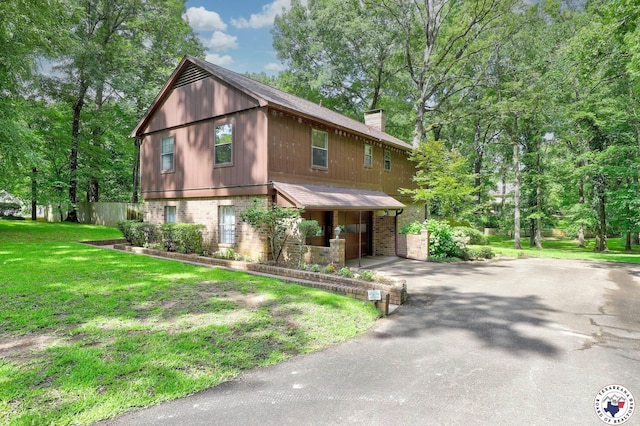 21 Holly Ridge Dr, Texarkana, TX 75503 - chalet / cabin featuring driveway, a chimney, brick siding, and a front yard
