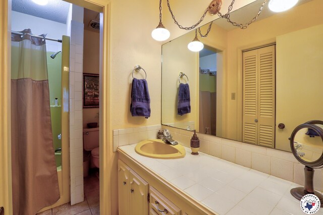 21 Holly Ridge Dr, Texarkana, TX 75503 - bathroom with a closet, vanity, shower / tub combo with curtain, tile patterned floors, and backsplash