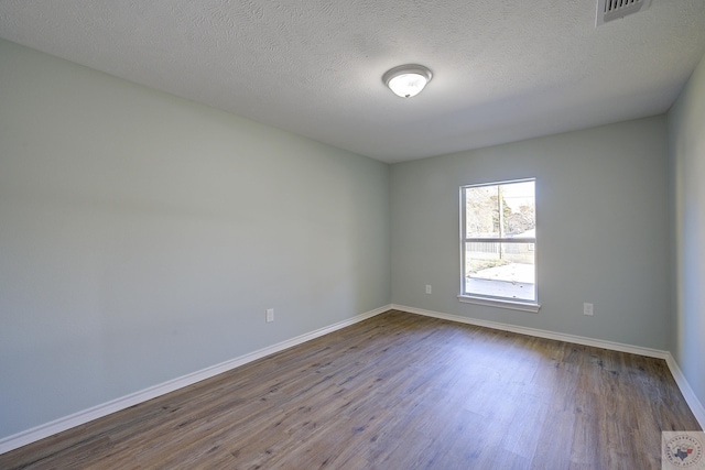 spare room featuring hardwood / wood-style flooring and a textured ceiling