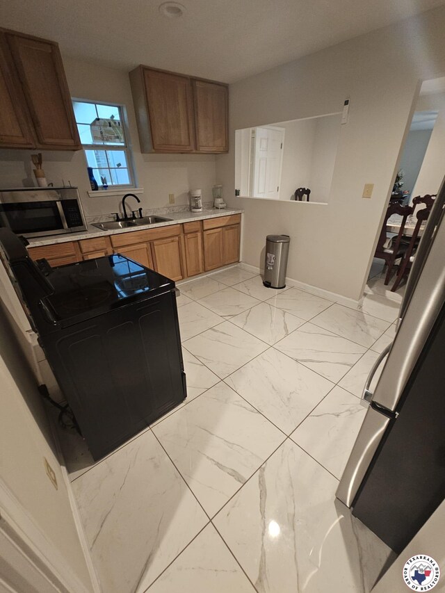 3514 Magnolia St, Texarkana, TX 75501 - kitchen with stainless steel microwave, range, light countertops, and light marble finish floors