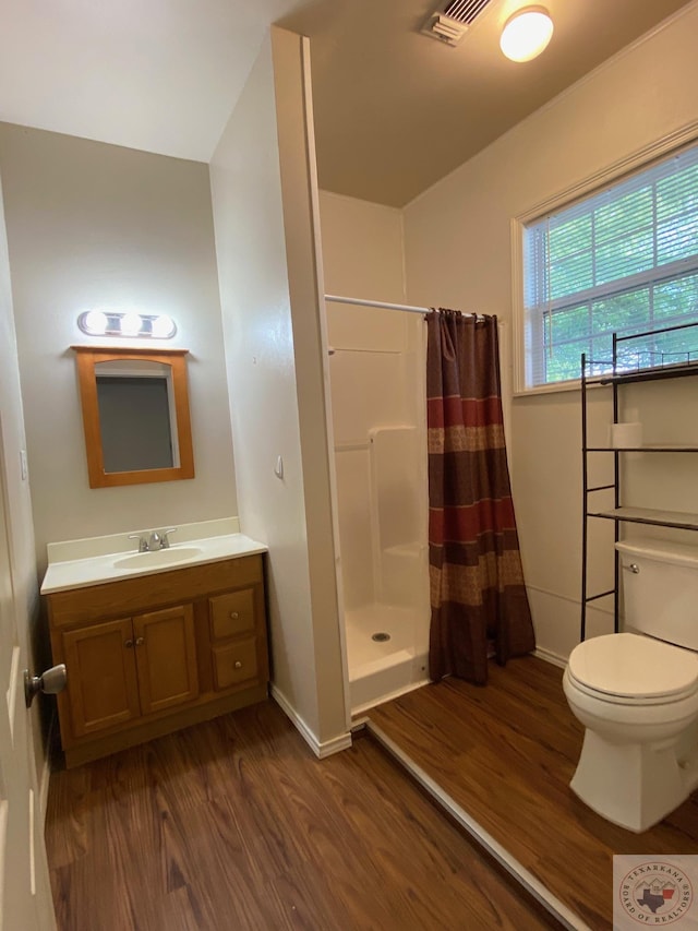 bathroom with curtained shower, hardwood / wood-style floors, toilet, and vanity