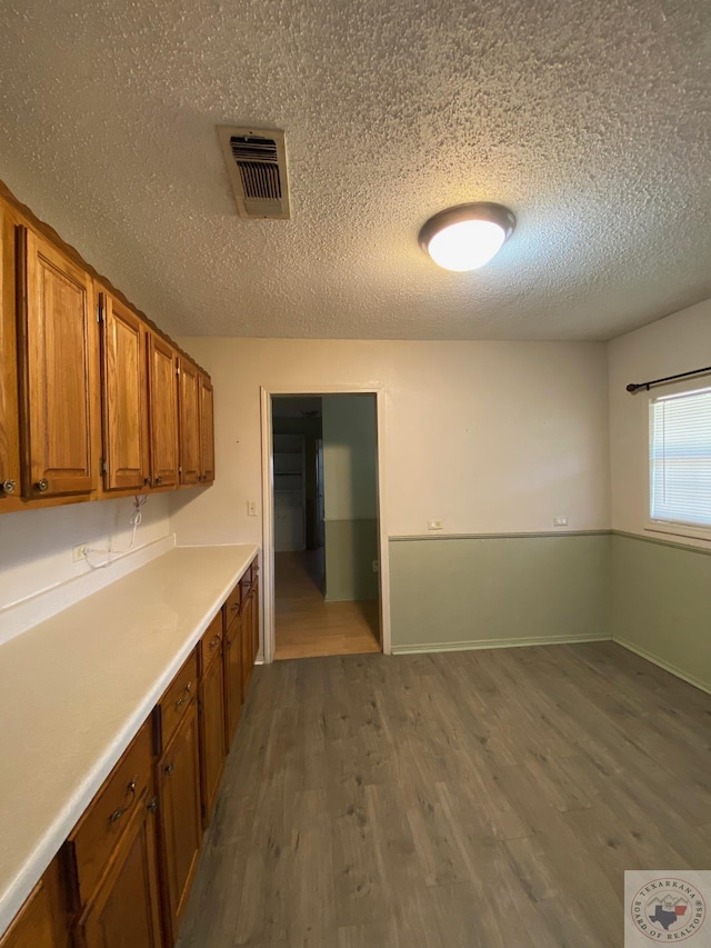 kitchen with hardwood / wood-style floors and a textured ceiling