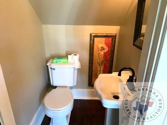 bathroom featuring vaulted ceiling and toilet