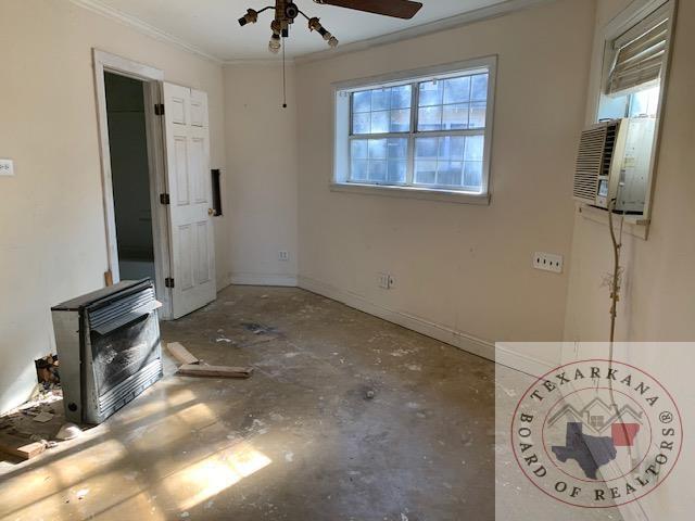 interior space with ceiling fan, ornamental molding, and concrete flooring