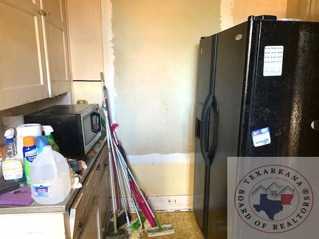 kitchen with white cabinets and black fridge