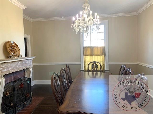 dining space featuring crown molding, dark wood-type flooring, and a notable chandelier